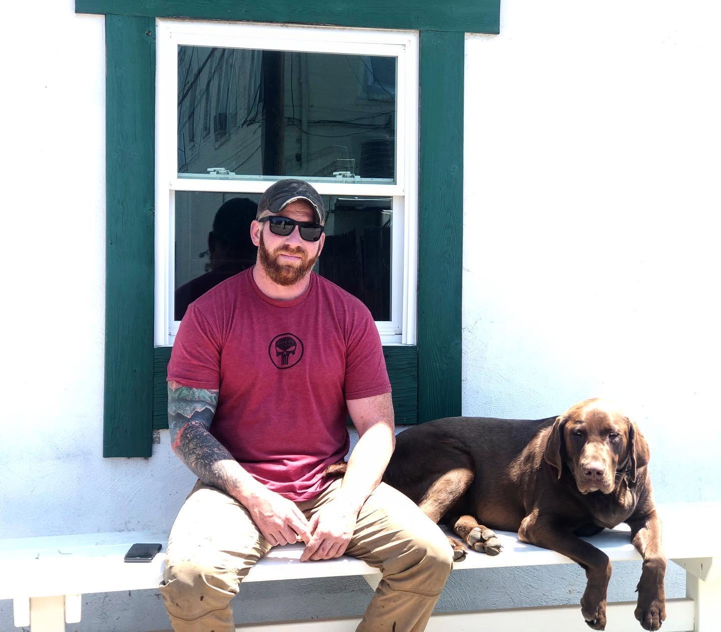 Jake with his dog outside the workshop.